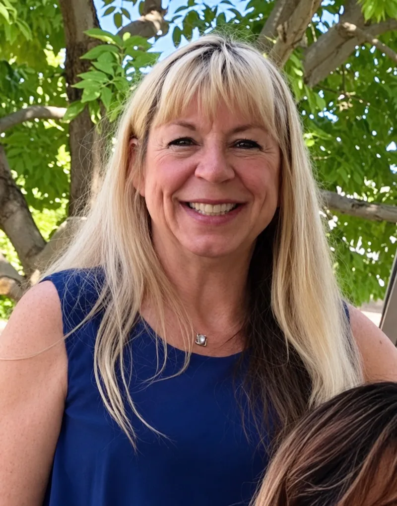 Tracy Christianson, smiling outdoors in a blue dress